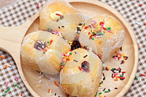 A variety of jam doughnut on wooden plate