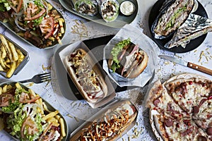 Variety of junk food dishes on the table. Hot dogs, French fries, salchipapas