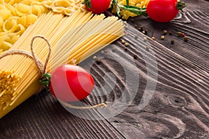 Variety of kinds and forms of dry macaroni with tomatoes and rosemary. Italian macaroni raw food or texture: pasta photo