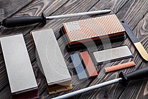 A variety of knife sharpeners. Sharpening stones and devices on a wooden background. Grinding stones