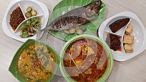 A variety of Minahasan (Manado) dishes are presented on a light-colored tabletop