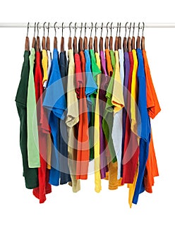 Variety of multicolored shirts on wooden hangers photo