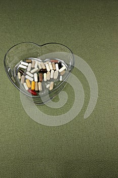 Variety of Nutritional Supplements in a Clear Heart Shaped Dish