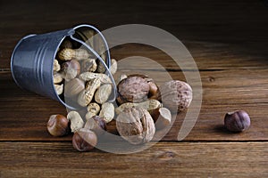 Variety nuts, peanuts, walnuts and hazelnuts wooden background