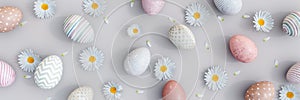 Variety of painted Easter eggs with spring flowers decoration on gray background