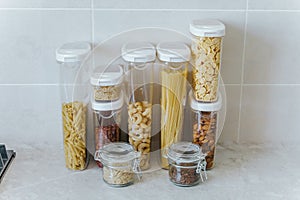 A variety of pasta, rice, cereals, nuts in containers-cans. The concept of proper convenient rational storage of food in the