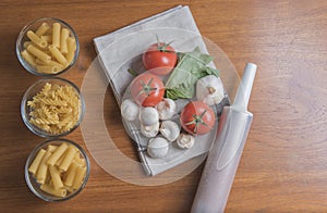 Variety of pasta with tomatoes, basil, mushrooms and garlic