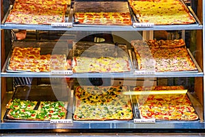 Variety of pizza slices on display for takeaway at Camden Market in London photo