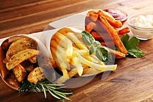 Variety of potatoes with fries. potato wedges, french fries, sweet potato for lunch on table