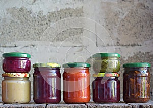 Variety of preserved food in glass jars - pickles, jam, marmalade, sauces, ketchup. Preserving vegetables and fruits. Fermented