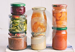 Variety of preserved food in glass jars - pickles, jam, marmalade, sauces, ketchup. Preserving vegetables and fruits. Fermented