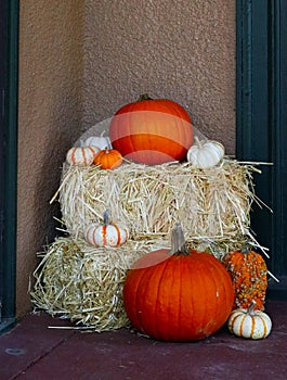 Variety of Pumpkins on Hay Bales - Fall Halloween Decor beside entrance of home