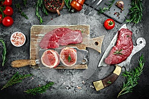 Variety of raw black angus prime meat steaks beef rump steak, Tenderloin fillet mignon for grilling on old meat cleaver on dark