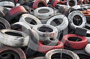 Variety of red white and black waste car tires piled