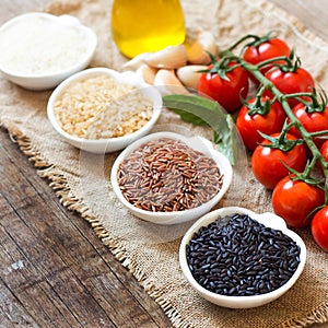 Variety of rice in bowls on wooden table