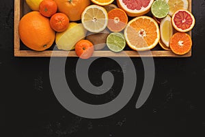 Variety of ripe citruses on black background