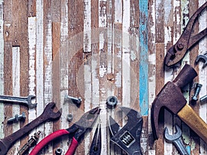 Variety rusty handy tools on grunge wooden background. Labor da