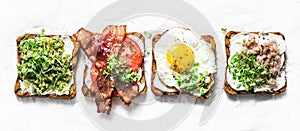 Variety of sandwiches for breakfast, snack, appetizers - avocado puree, fried egg, tomatoes, bacon, cheese, smoked mackerel