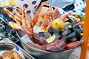 Variety of seafood serve in bucket on wooden table. Grilled seafood delicatessen: mussels and blue crabs. Sea food