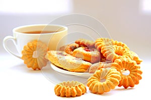 A variety of shaped cookies. White cup of tea. Morning is sweet. Tea ceremony.