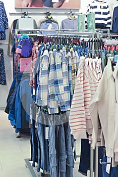 Variety of shot and jeans on hangers in kids clothes store