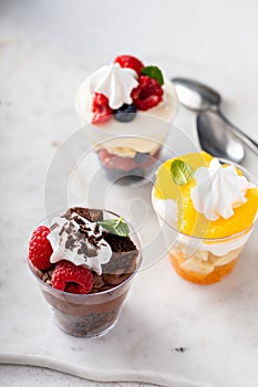 Variety of small desserts in cups, chocolate, berry and orange