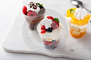 Variety of small desserts in cups, chocolate, berry and orange