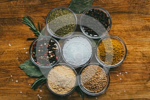 Variety of spices in round glass bowls - ground ginger, hops-suneli, kari, black pepper and a mixture