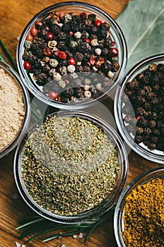 Variety of spices in round glass bowls - ground ginger, hops-suneli, kari, black pepper and a mixture
