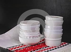 White creal and soup bowls stacked on a black table