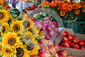 A variety of sunflowers and apples on display at a bustling farmers market, A bustling farmers market filled with fresh produce