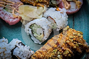 A variety of supermarket sushi on a rustric platter - close-up