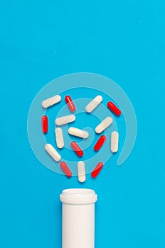 Variety of tablets and pills.Pharmaceuticals and antibiotics heart-shaped bottle on blue background.