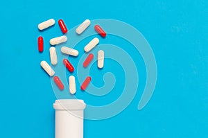 Variety of tablets and pills.Pharmaceuticals and antibiotics heart-shaped bottle on blue background.