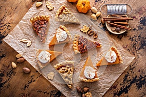 Variety of Thanksgiving pie slices on parchment paper