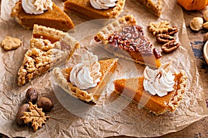 Variety of Thanksgiving pie slices on parchment paper