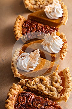 Variety of Thanksgiving pie slices on parchment paper
