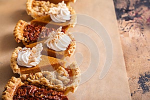 Variety of Thanksgiving pie slices on parchment paper