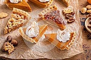 Variety of Thanksgiving pie slices on parchment paper