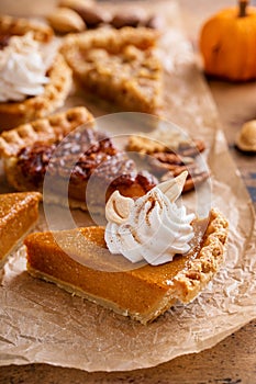 Variety of Thanksgiving pie slices on parchment paper