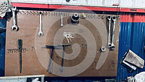 Variety of tools such a spanners, wrench holding on the wooden wall