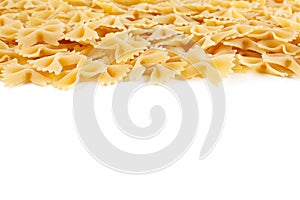 A variety of types and shapes of Italian pasta. Dry pasta bows farfalle .  Heap of bow tie macaroni isolated on white background