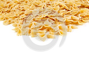 A variety of types and shapes of Italian pasta. Dry pasta bows farfalle .  Heap of bow tie macaroni isolated on white background