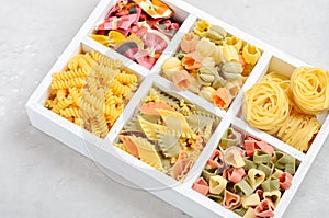 Variety of types and shapes of raw Italian pasta.