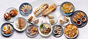 A variety of vegan Asian fusion meals as burger, sandwiches, dumplings, noodles, chickpea steak, rolls and jackfruit drumsticks