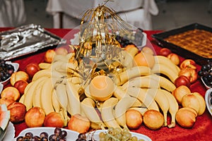 Variety of vibrant and delectable fruits on a red tabletop