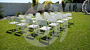 Variety of white folding chairs in the reception area of the marriage on the wedding ceremony.