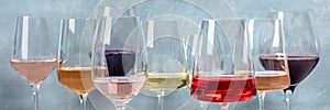 Variety of wine colors panorama. Red, rose, and white wine in elegant glasses