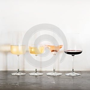 Variety of wine types over concrete table, square crop