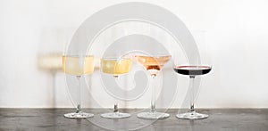 Variety of wine types over concrete table, wide composition